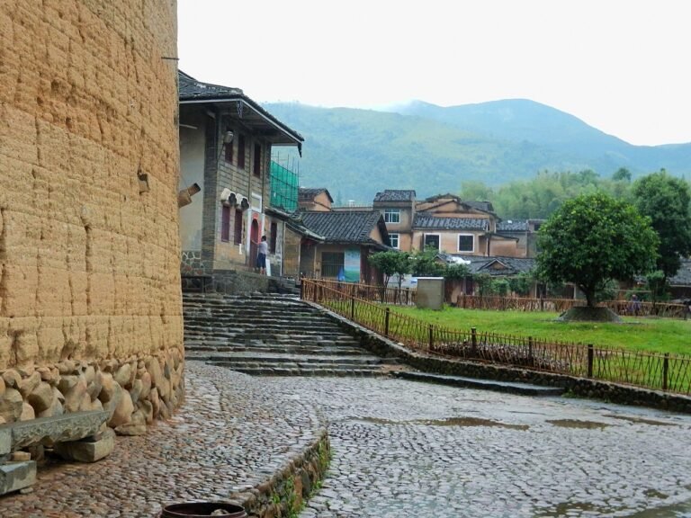 Tulou village lane in Yongding, Fujian — rammed-earth walls and stone paving